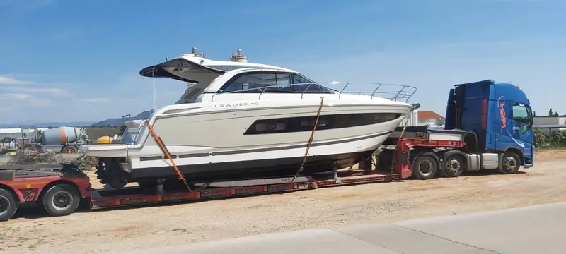 Barcă cu motor ancorată pe trailer cu platformă joasă