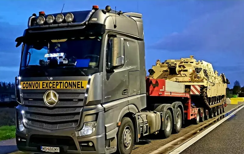 Vehicul blindat pe trailer cu platformă joasă, cu panou de convoi excepțional pe camion