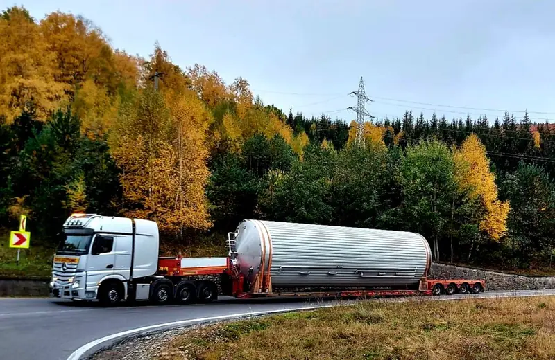 Rezervor cilindric mare transportat pe semiremorcă extensibilă, pe un drum de munte